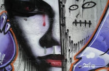 graffiti con rostro partido: un lado realista y otro garabateado