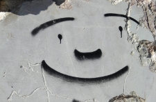 Graffiti con cara sonriente y trazos muy simples