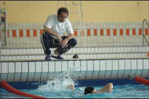 El entrenador Simon Calmat (Vincent Lindon) observa a Bilal en un piscina