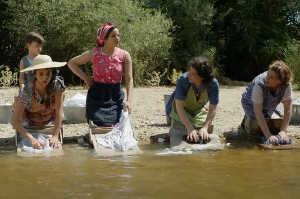 Jacinta (Penlope Cruz), primera mujer por la izquierda, en una escena inicial de 'Dolor y gloria', lavando en el ro