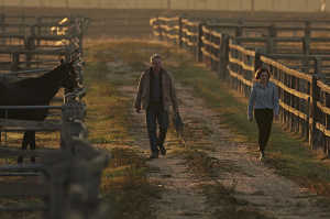 Michelle Payne (Teresa Palmer) junto a su padre, Paddy Payne (Sam Neill) en su rancho de caballos
