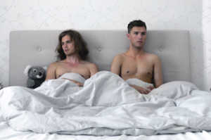 Hampus (Jonathan Andersson) en la parte derecha de la cama y Adrian (Björn Elgerd), a la izquierda