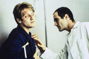 James Ballard (James Spader) dej�ndose examinar por Vaughan (Elias Koteas) extadiado con las heridas de su cuerpo