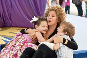 Los gemelos Samantha (Daisy Tahan) y Henry (Colin Baiocchi) abrazados a su abuela, Roz (Barbra Streisand)
