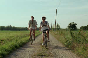 Oliver (izd) y Elio (dch) en bibicleta por el campo lombardo